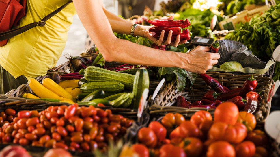 man-choosing-vegetable-from-vegetable-stall-at-supermarket